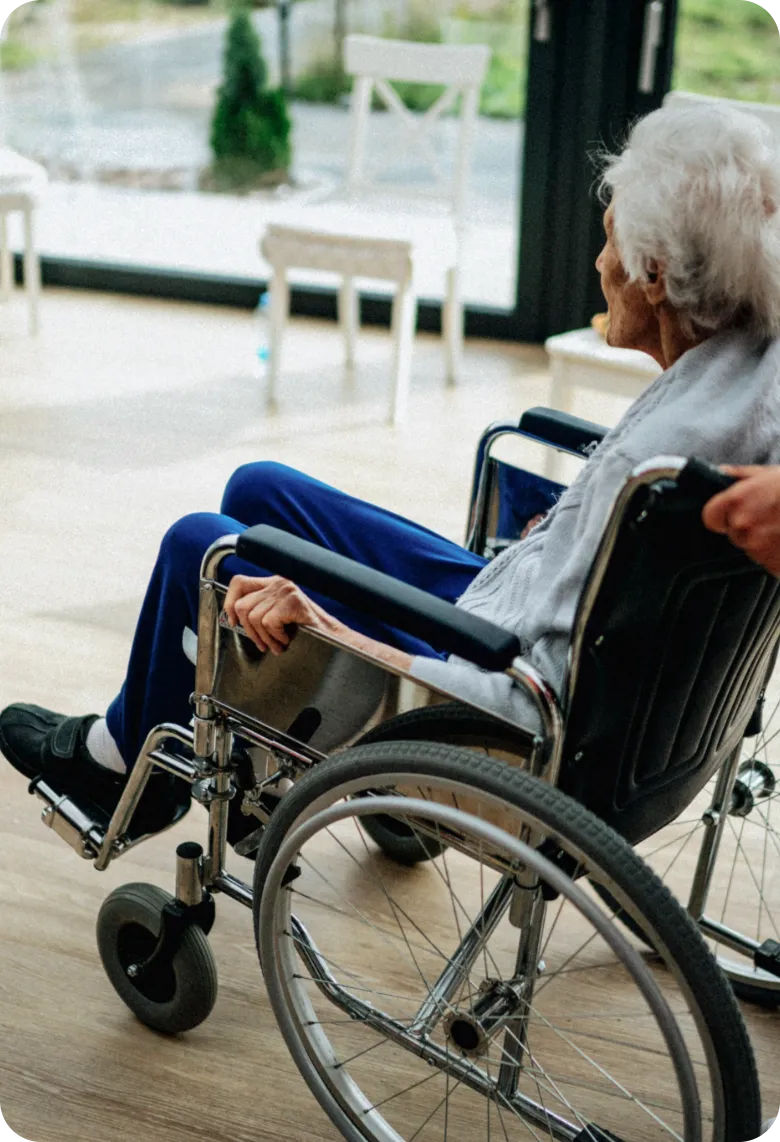 In-Home Wheelchair Assistance for a Senior Woman | Comfort Home Care Caregiver assisting a senior woman in a wheelchair inside her home