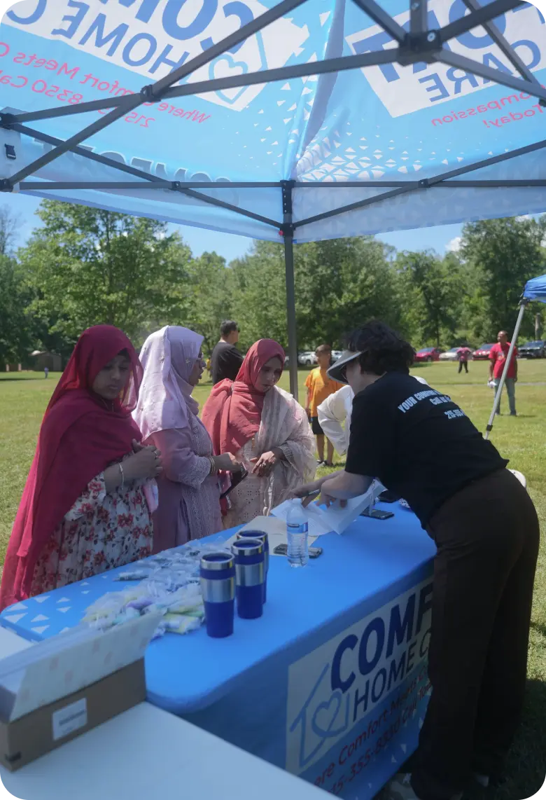 comfort-home-care-community-outreach-booth | Comfort Home Care Comfort Home Care team member assisting visitors at a community outreach event booth