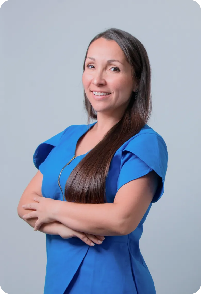 Professional Home Caregiver in Blue Scrubs | Comfort Home Care Smiling professional home caregiver in blue scrubs with arms crossed